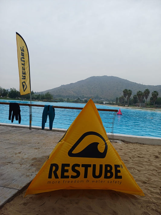 Se muestra una boya de demarcacion triangular RESTUBE inflada antes de ser instalada en el agua para un evento de deportes acuaticos