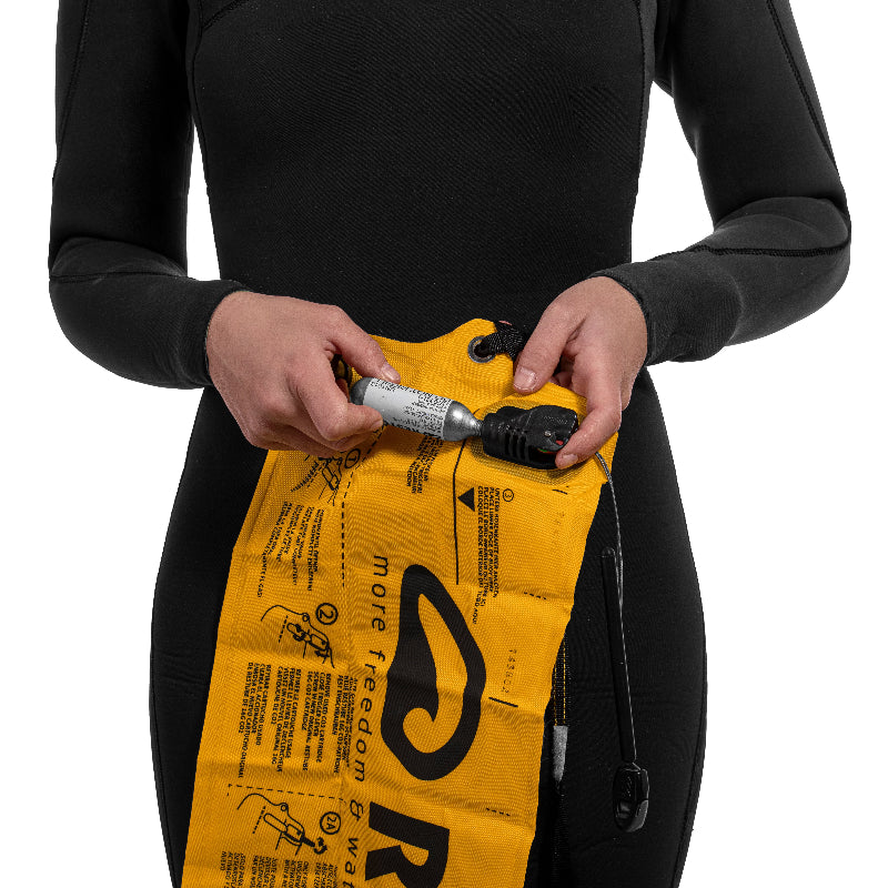 Foto en detalle que muestra el mecanismo de accionamiento de la boya Restube Beach. Se muestra el cartucho de CO2 con rosca siendo instalada en el mecanismo de accionamiento