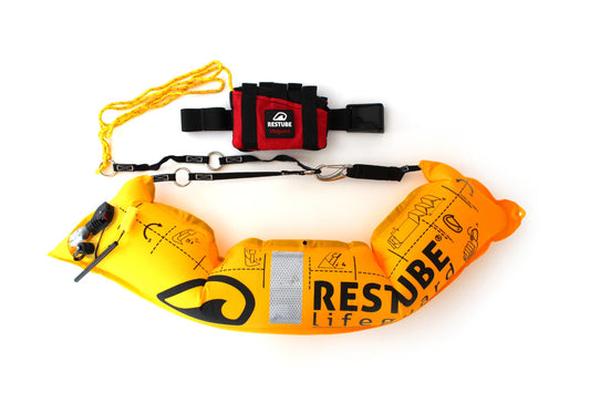 Se muestra el dispositivo RESTUBE LIFEGUARD de color rojo con su boya tubular amarilla inflada, poniendo en accion los accesorios como el cinturon ajustable para remolcar victimas o el cordín de remolque que trae el dispositivo. Todo esto busca apoyar positivamente las labores de los profesionales del rescate acuático
